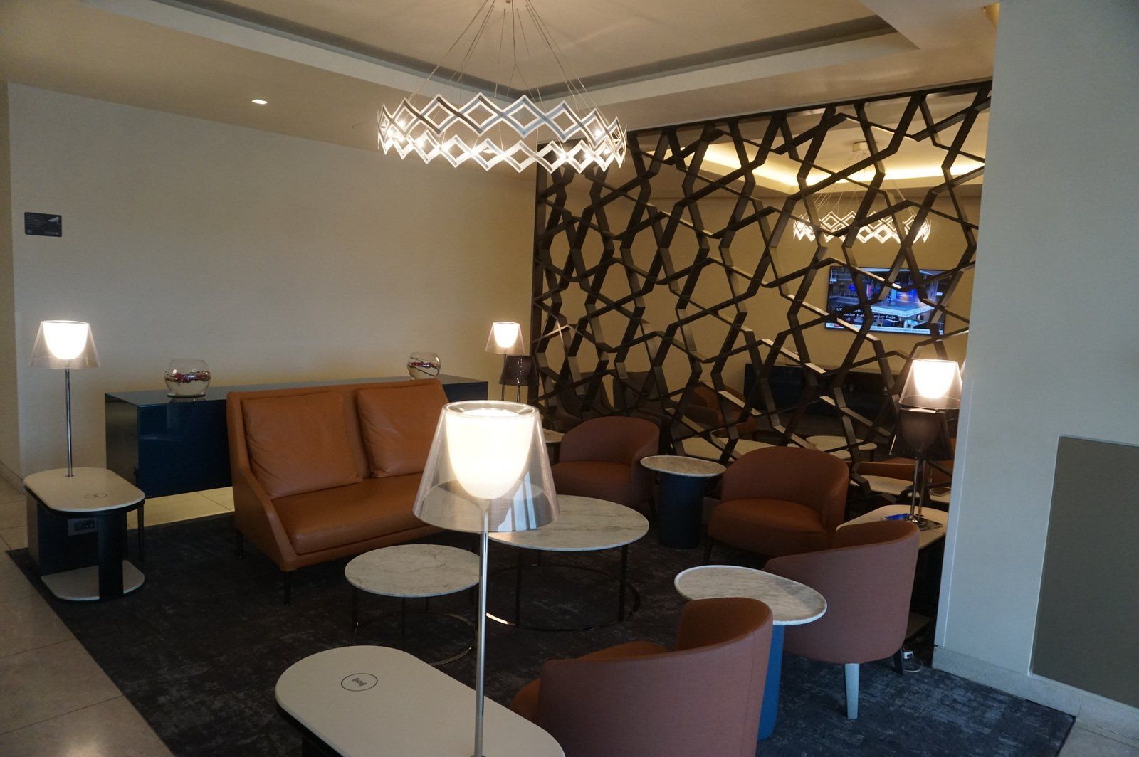Seating with armchairs and low tables in the Qatar Airways lounge at Heathrow Terminal 4.
