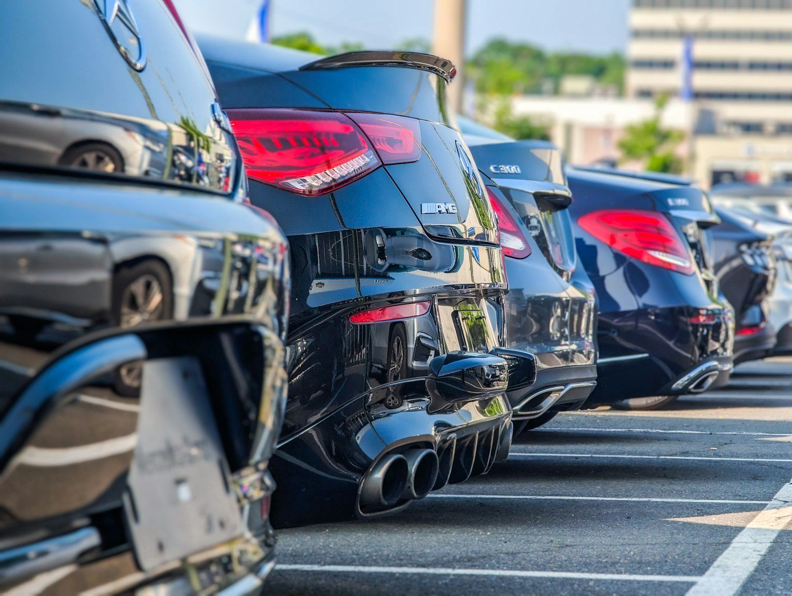 A row of cars parked in a lot, seen from behind.